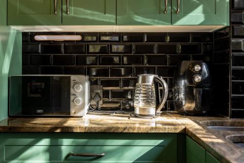 a kitchen counter with a microwave on a counter top at New Mountain Retreat with Scenic Views in Hout Bay