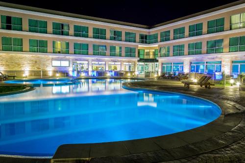 a hotel with a large swimming pool at night at Howard Johnson Neuquen in Neuquén