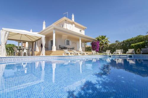 a villa with a swimming pool in front of a house at Villa Tulipa by Algarve Holidays in Albufeira