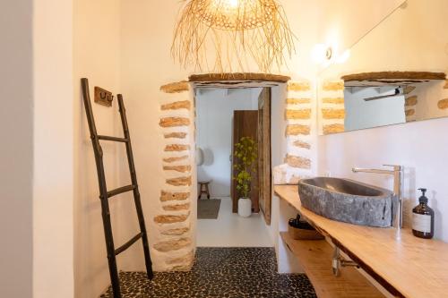 a bathroom with a stone sink and a ladder at Hotel Can Sastre in Santa Gertrudis de Fruitera