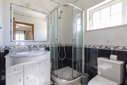 a bathroom with a shower and a sink and a toilet at Villa Tulipa by Algarve Holidays in Albufeira