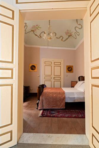 a bedroom with a bed and a chandelier at Roccamelia Experience in Mazara del Vallo