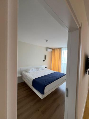a bedroom with a bed with a blue blanket at Batumi Best View in Batumi