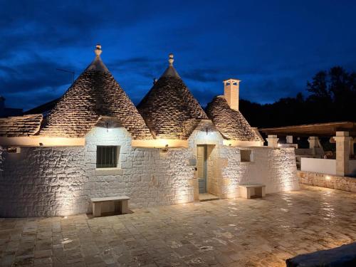 a stone building with lights on it at night at Luxury Trulli di Giulia, exclusive villa with private pool in Valle d'Itria Ostuni - BR, Puglia in Ostuni
