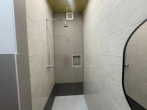 a shower with a glass door in a bathroom at Lyon House Hotel in Barking