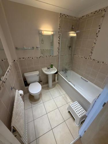 a bathroom with a toilet and a tub and a sink at Ballard Down View, Swanage 2 Bed in Swanage