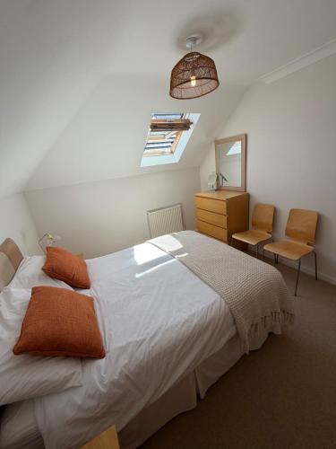 a bedroom with a bed and a dresser and a mirror at Ballard Down View, Swanage 2 Bed in Swanage
