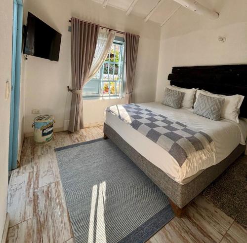a bedroom with a large bed and a window at HOTEL BOUTIQUE Santa Helena in Villa de Leyva