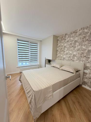a bedroom with a large bed with a stone wall at Inamstro Home in Orhei