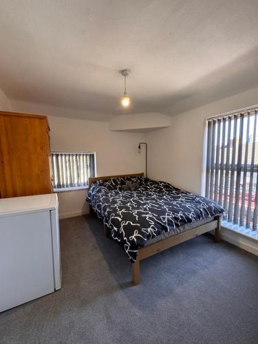 a bedroom with a bed in a room with windows at Serenity LTD in Leicester