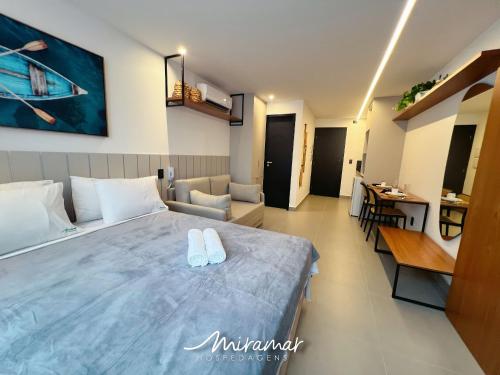 a bedroom with a bed with two white slippers on it at Emunah-Ponta de Campina Cabedelo in Cabedelo