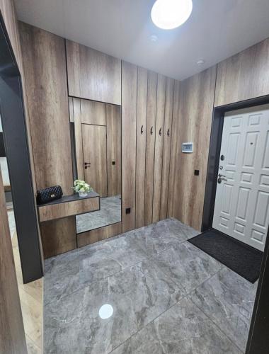 a bathroom with wooden walls and a white door at Бауржан Момушелы 28 in Fëdorovka