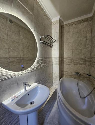 a bathroom with a sink and a tub and a mirror at Бауржан Момушелы 28 in Fëdorovka