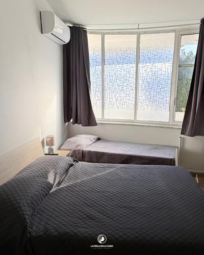 two beds in a bedroom with a window at la perla dello ionio in Satriano
