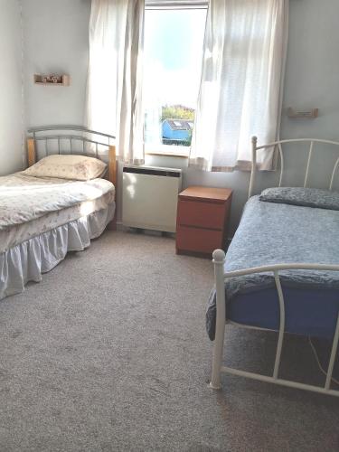 a bedroom with two beds and a window at Sawston Village in Sawston