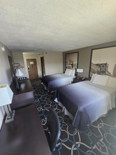 a hotel room with two beds and a desk at Super 8 by Wyndham Kansas City in Kansas City