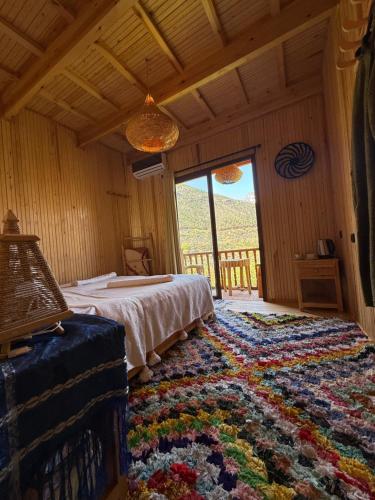 a bedroom with a bed and a large rug at Jnane Karma in Imlil