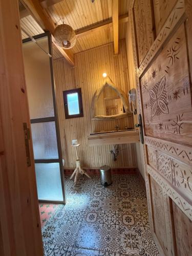 a bathroom with a door and a room with a mirror at Jnane Karma in Imlil