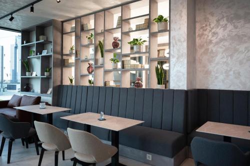 a restaurant with two tables and chairs and plants at Diamond2 Hotel in Zagreb