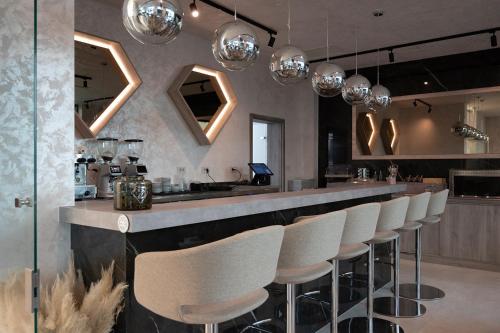 a bar with a row of white bar stools at Diamond2 Hotel in Zagreb