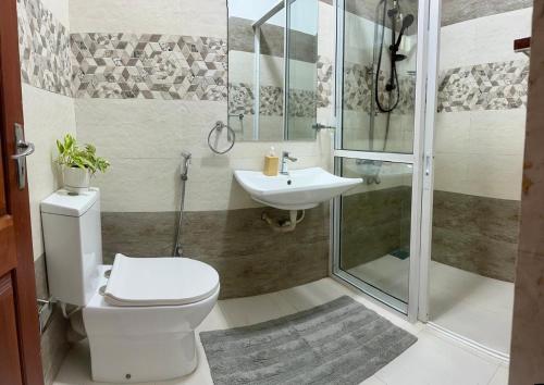 a bathroom with a toilet and a sink and a shower at Hamilton Breeze villa in Pamunugama