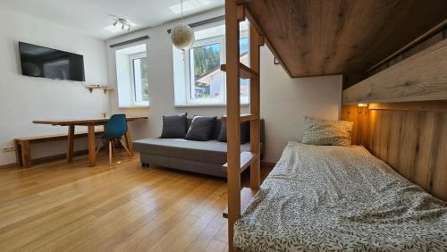 a bedroom with a bed and a desk and a table at Ski & Sky Apartment in Hinterstoder