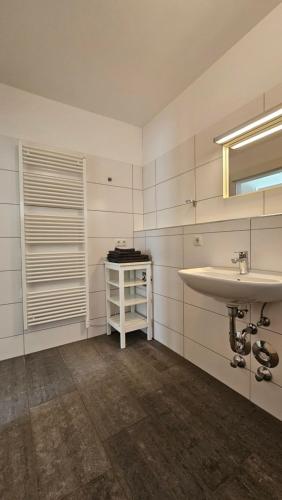 a white bathroom with a sink and a window at Ski & Sky Apartment in Hinterstoder