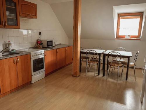 a kitchen with a table and chairs in a kitchen at Penzion Leona in Obecnice