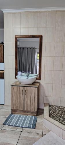 a bathroom with a sink and a mirror at Drakensberg Rest in Kimberley