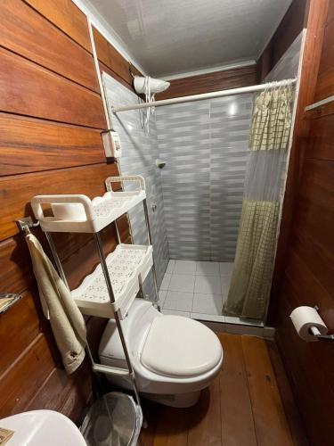 a bathroom with a toilet and a shower at Coco house tambopata in Puerto Maldonado