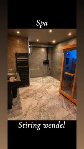 a bathroom with a marble floor and a stone wall at Royal SPA Saarbrucken in Stiring-Wendel