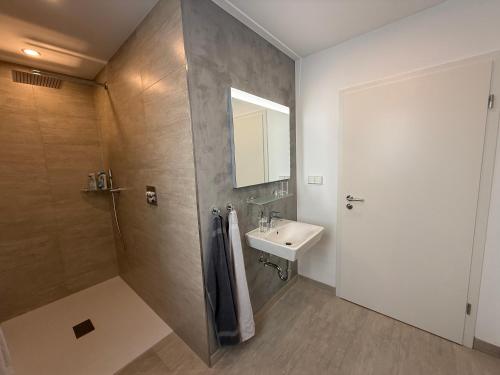 a bathroom with a sink and a shower with a mirror at Ferienwohnung Ruhepunkt Dessau - zentral nahe Bauhaus und Meisterhäusern - mit gratis WLAN und Parken sowie Komplettküche in Dessau