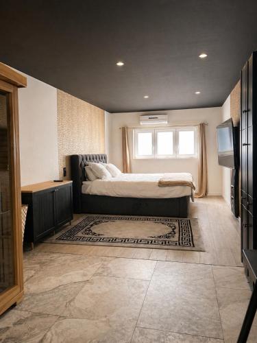 a bedroom with a bed and a window and a television at Royal SPA Saarbrucken in Stiring-Wendel