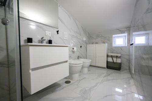 a white bathroom with a toilet and a shower at Dimora Ambrosio 108 in San Giuseppe Vesuviano