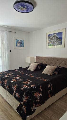 a bedroom with a large bed with a black blanket at Apartman NIKOL in Senj