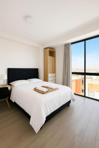 a white bedroom with a large bed and a large window at Costanera Hotel in San Juan