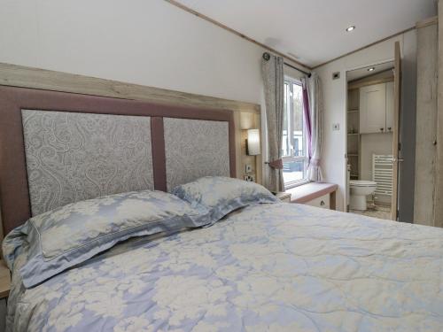 a bedroom with a large bed and a window at Carp Lodge in Carnforth