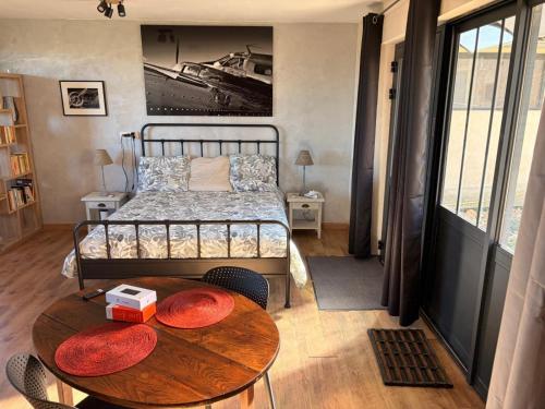 a bedroom with a bed and a wooden table with a table at La Perle Rare in La Barthe