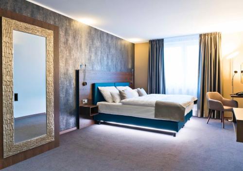 a bedroom with a large bed and a mirror at Steinberger Hof in Dietzenbach