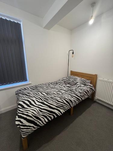 a zebra print bed in a room with a window at Serenity LTD in Leicester
