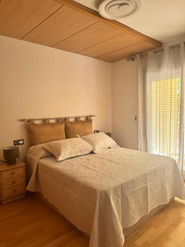 a bedroom with a large bed and a window at Suitte Catalunya in Calafell