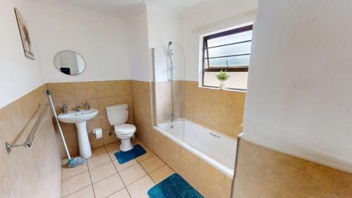a bathroom with a sink and a toilet and a bath tub at Noordhang Nest in Four Ways
