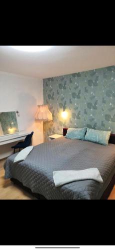 a bedroom with a large bed with a blue wall at Ferienwohnung am Bahnhof Schwerte mit Balkon in Schwerte
