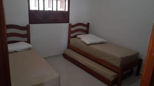 a bedroom with two twin beds and a window at Paraíso dos Falcões in Nísia Floresta