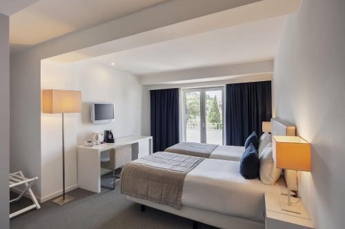 a hotel room with a bed and a window at Grace Smart Design Hotel - "Hotel Anjo de Portugal" in Fátima