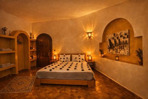 a bedroom with a bed and a painting on the wall at Riad les trois merveilles in Essaouira