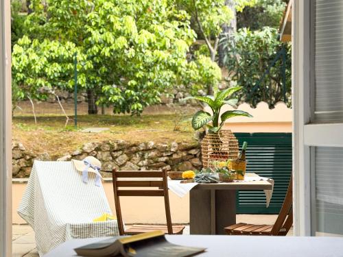 a table and chairs on a patio with a plant at Orizzonte Blu - HelloElba in Marciana Marina