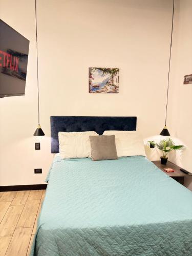 a bedroom with a bed with a blue comforter at Eon 2 - Apartamento en edificio con piscina in Estación Pamplona