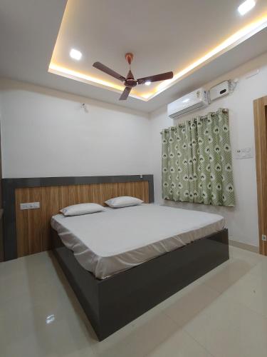 a bedroom with a bed with a ceiling fan at Anand palace lodge in Ghatgān