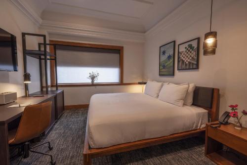 a hotel room with a bed and a desk and a computer at The Promissory Hotel in Roanoke